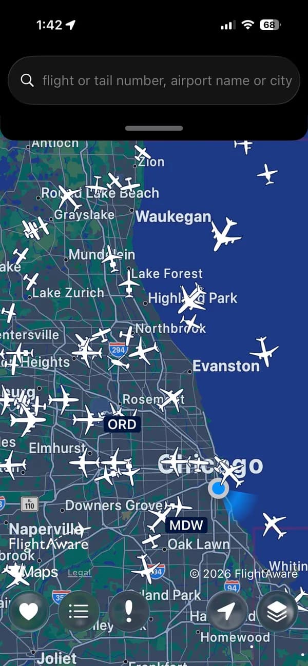 FlightAware showing live aircraft over Chicago on a dark map.